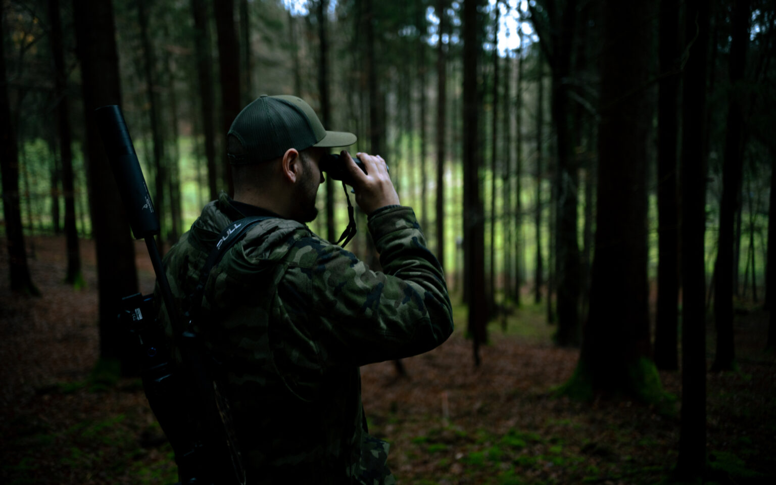 EP-Arms Jäger schaut durch Fernrohr im Wald